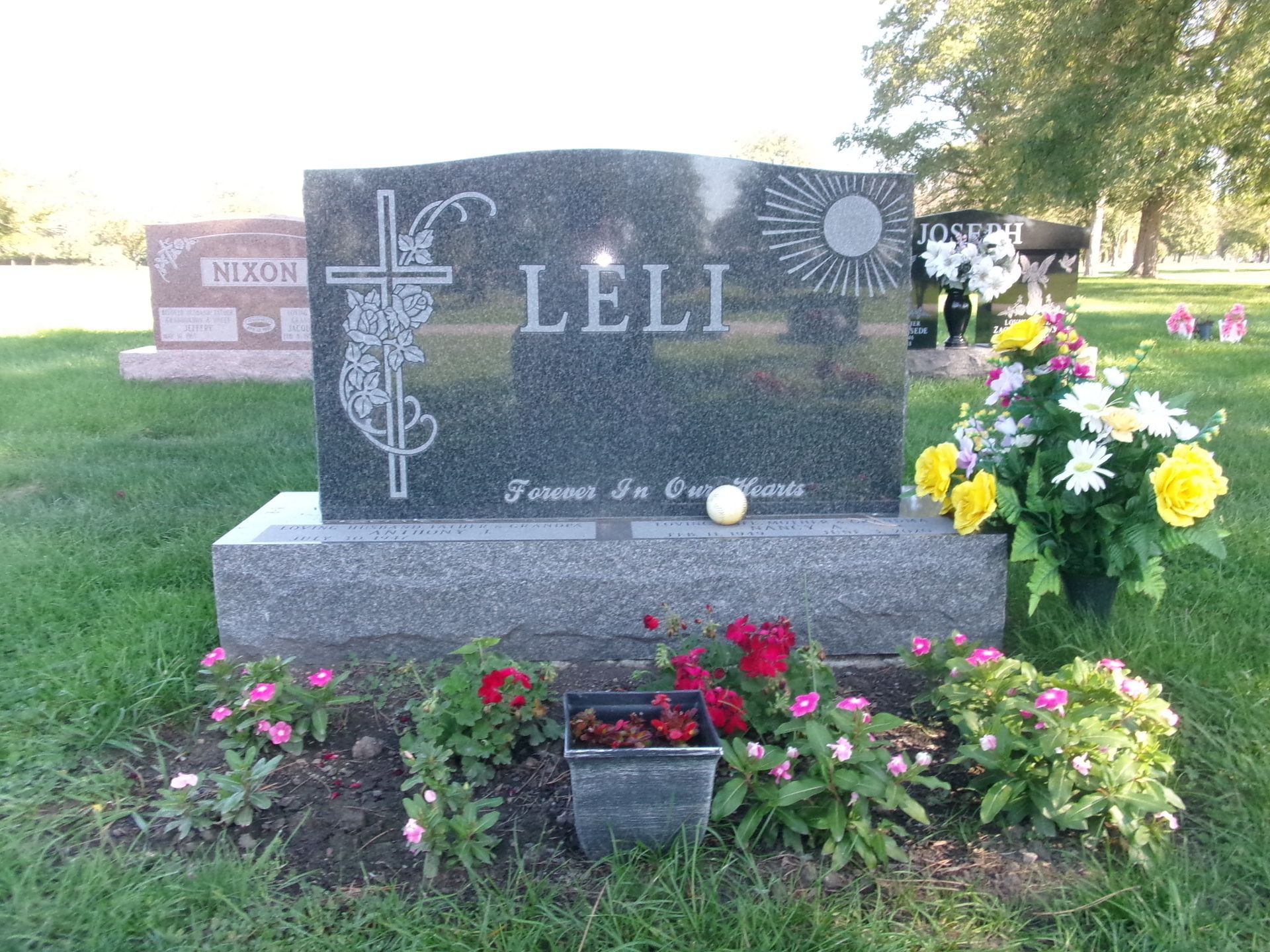 A dark gray granite headstone inscribed 