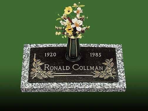 Grave marker with granite base and black top, floral arrangement in a vase, name Ronald Collman, birth/death years.
