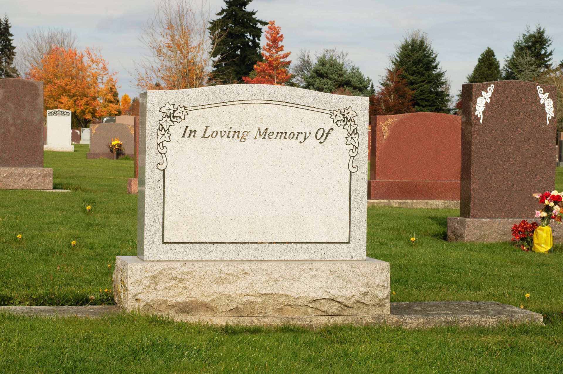 A cemetery featuring a granite headstone with In Loving Memory Of engraved at the top.