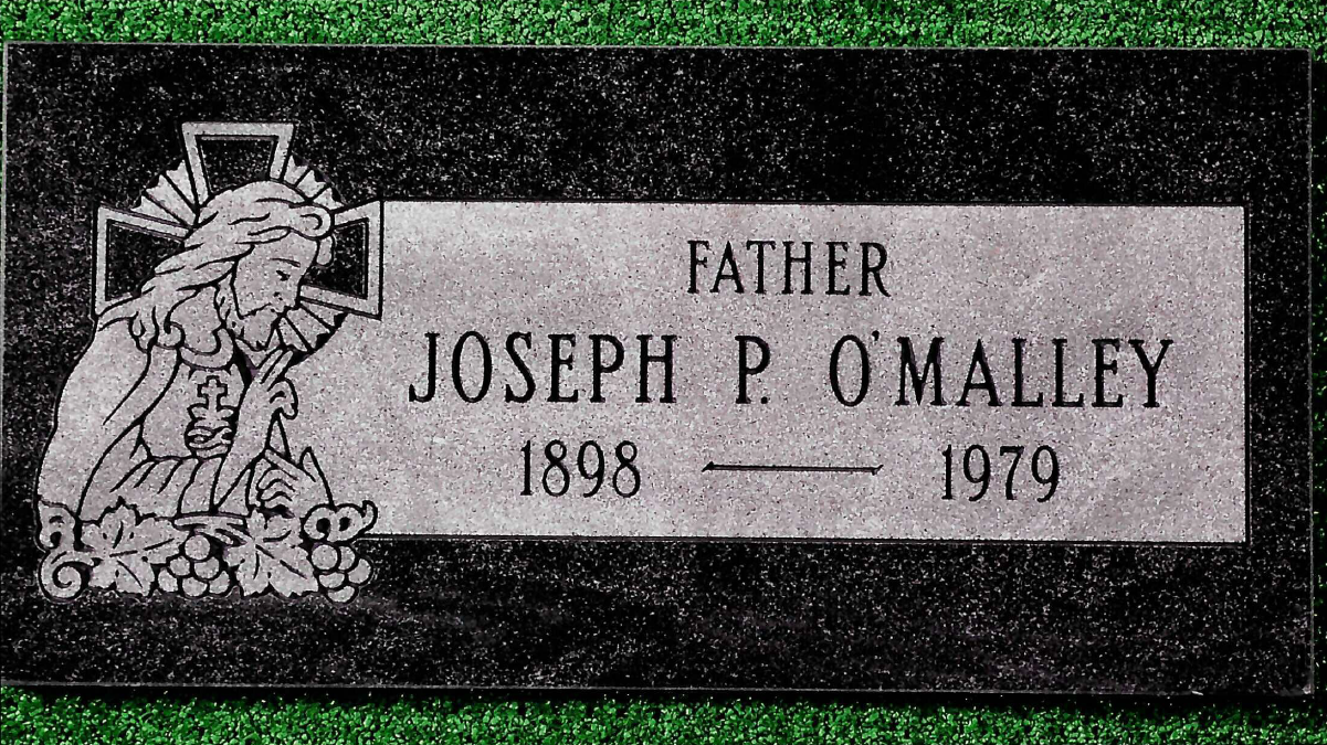 A rectangular black granite grave marker for Joseph P. O'Malley, 1898–1979, featuring an engraving of Jesus on a cross.