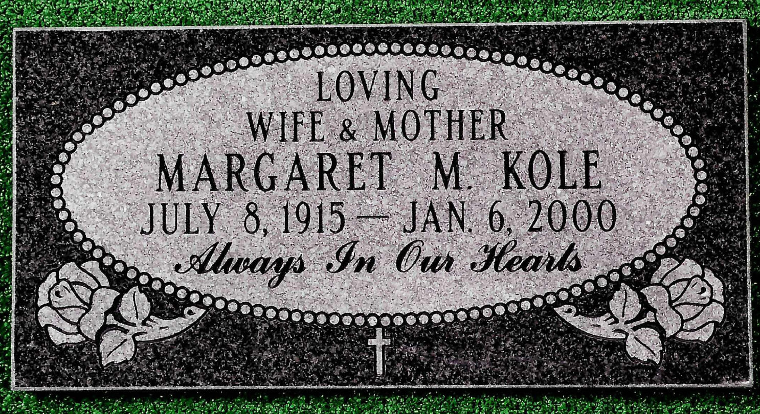 A black granite grave marker with an oval, beaded frame containing text for Margaret M. Kole, dated 1915–2000, with roses.