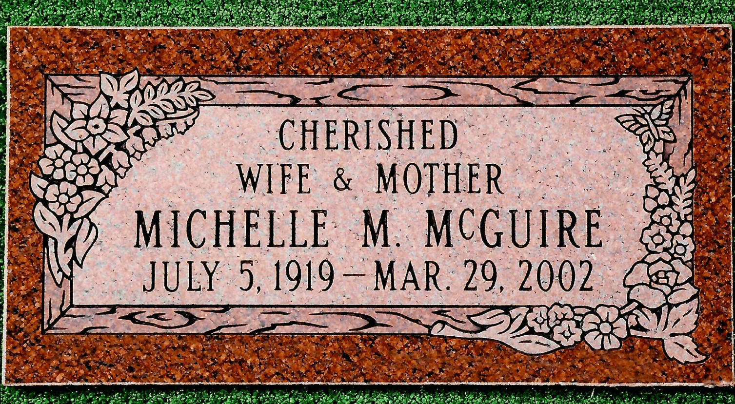 A rectangular granite grave marker with floral engravings, inscribed 