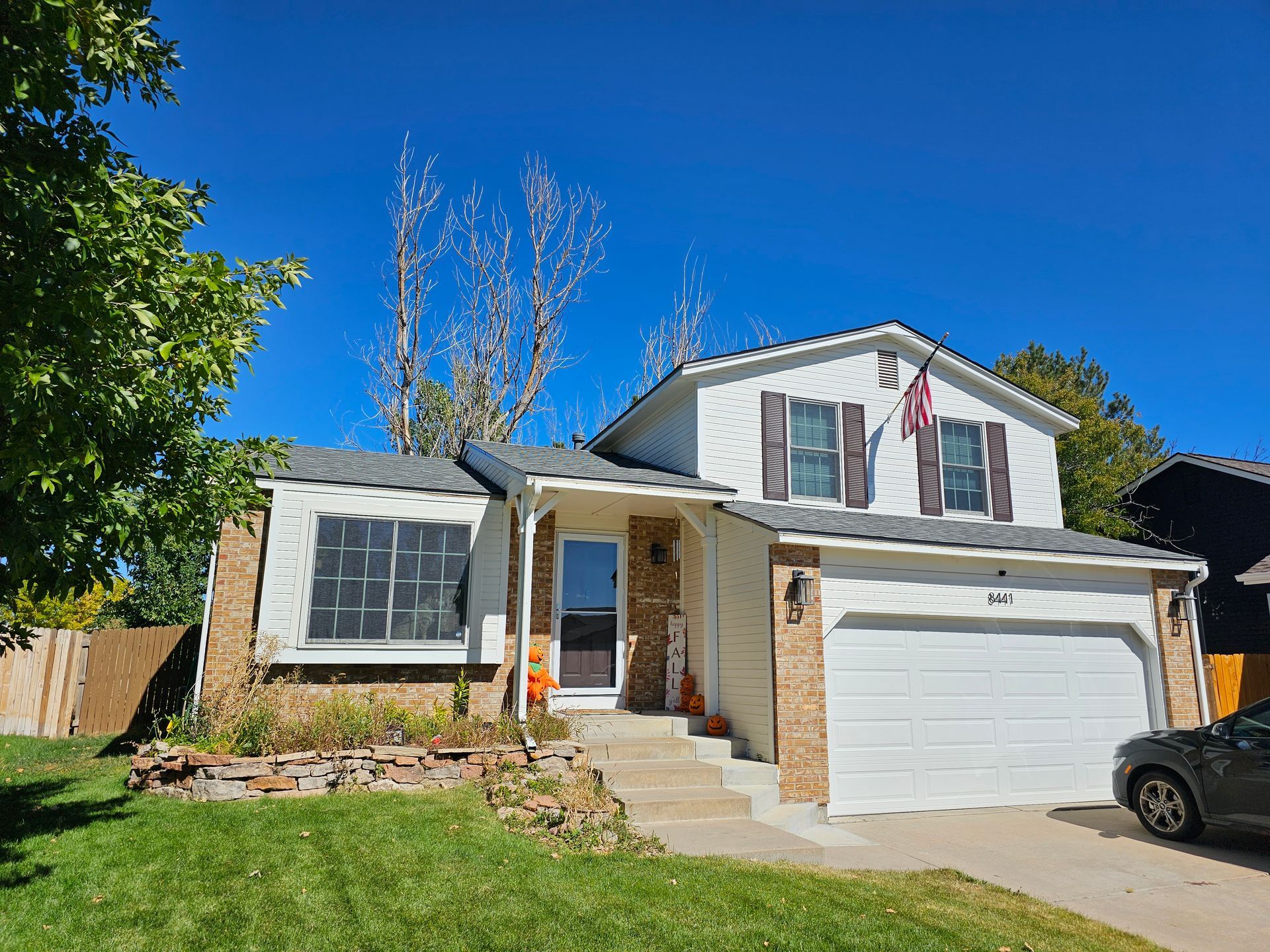 A person is using a drill to install a wooden fence.