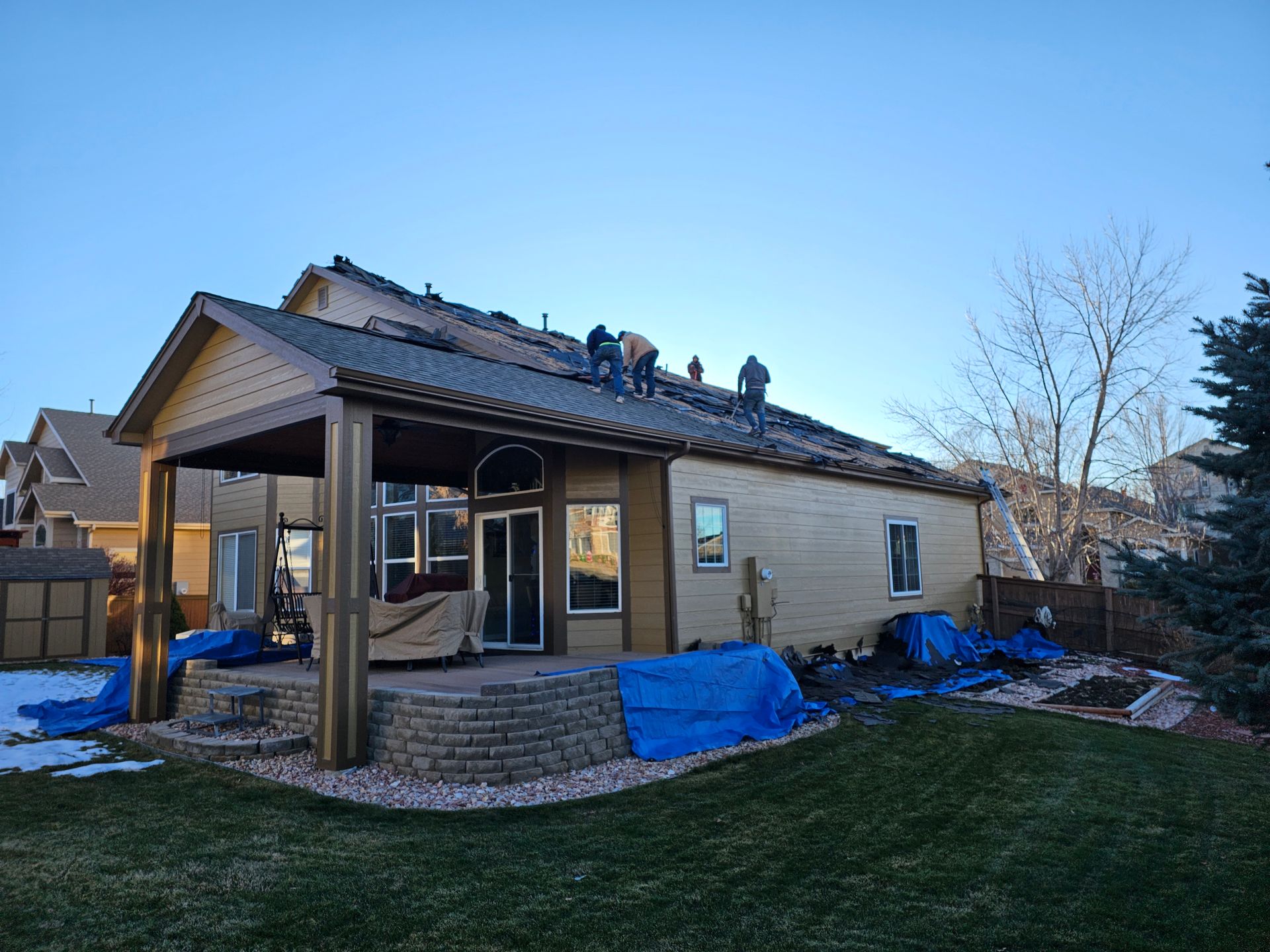 A person is using a drill to install a wooden fence.