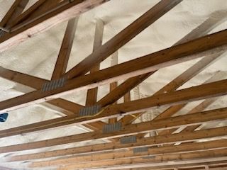 A ceiling with wooden beams and foam on it.
