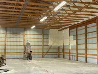 A man is standing on a ladder inside of a building.