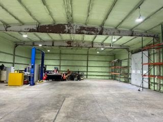 A large warehouse with a lot of shelves and a lift.