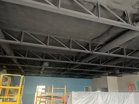 A large room with a ceiling that is being painted.