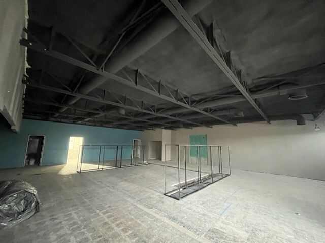 A large empty room with a black ceiling and a blue wall.