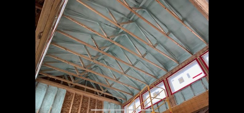 The ceiling of a building is being insulated with spray foam.