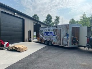 A trailer with the word ideal on it is parked in front of a building.