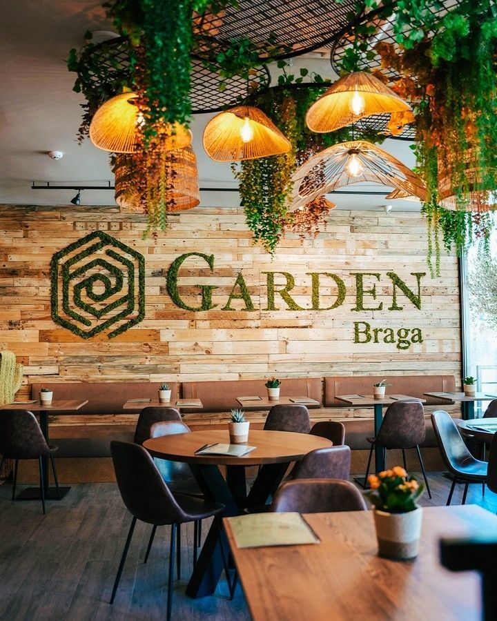 Um restaurante com mesas e cadeiras e uma placa que diz Garden Braga