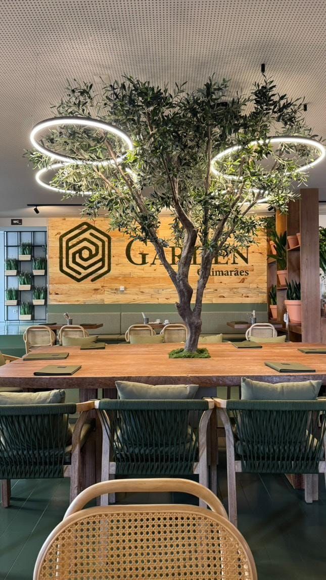 Um restaurante com mesas e cadeiras e uma placa que diz Garden Braga