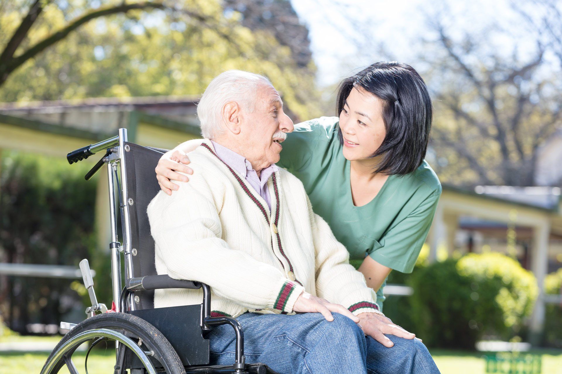 Asian-nurse-helping-elderly-man-on-wheelchair-outdoor