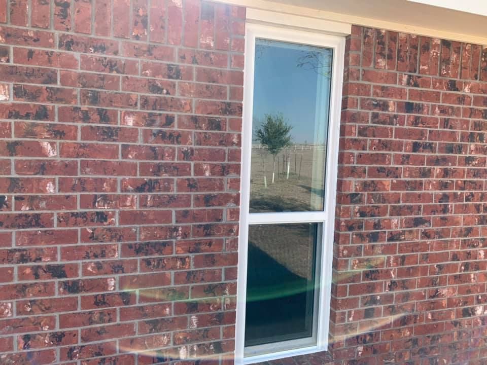 A red brick wall with a white window on it.