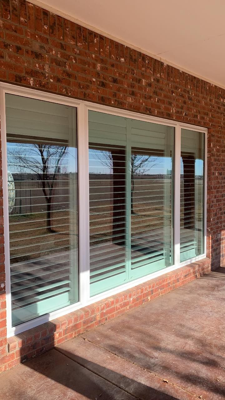 A brick building with a lot of windows and blinds on it.