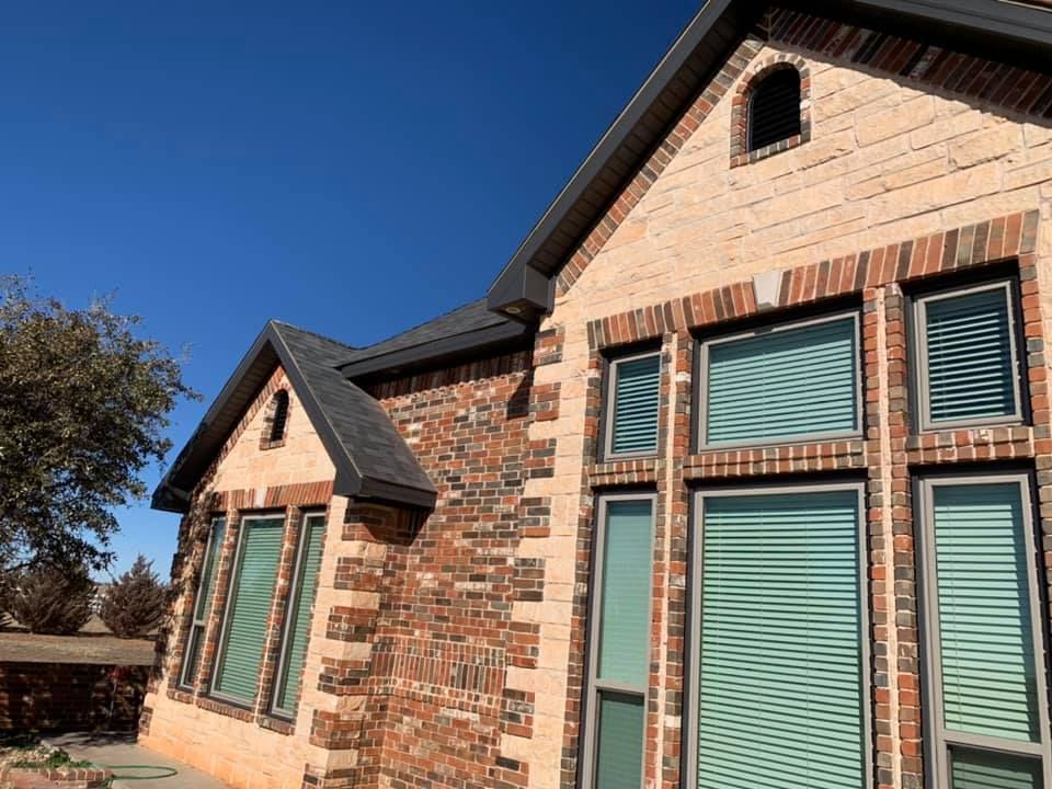 A brick house with a lot of windows and blinds
