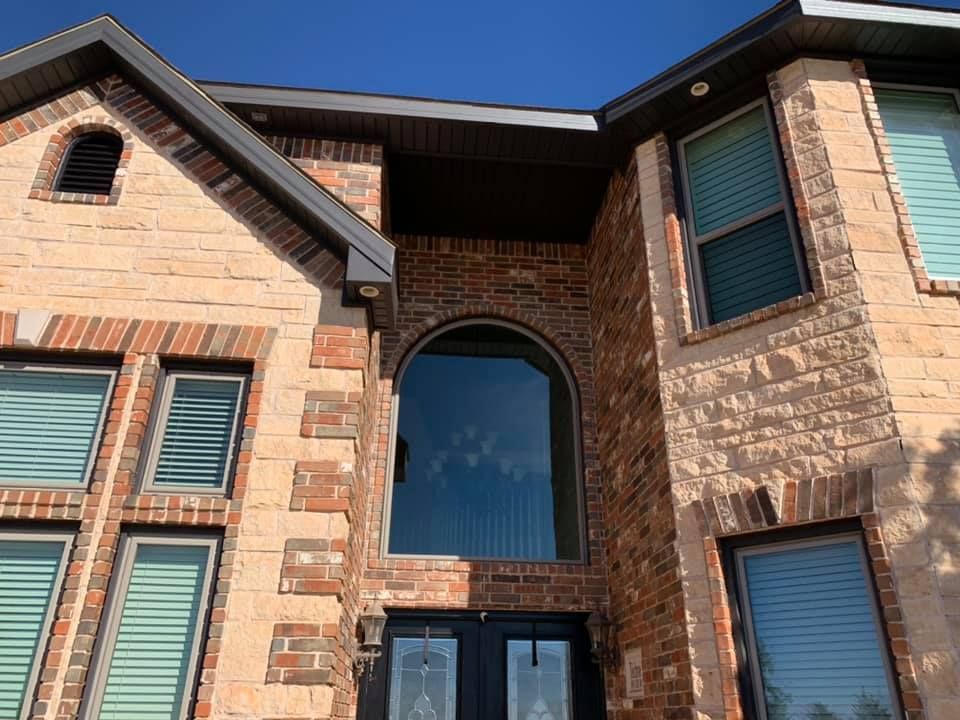 A large brick house with lots of windows and a black door