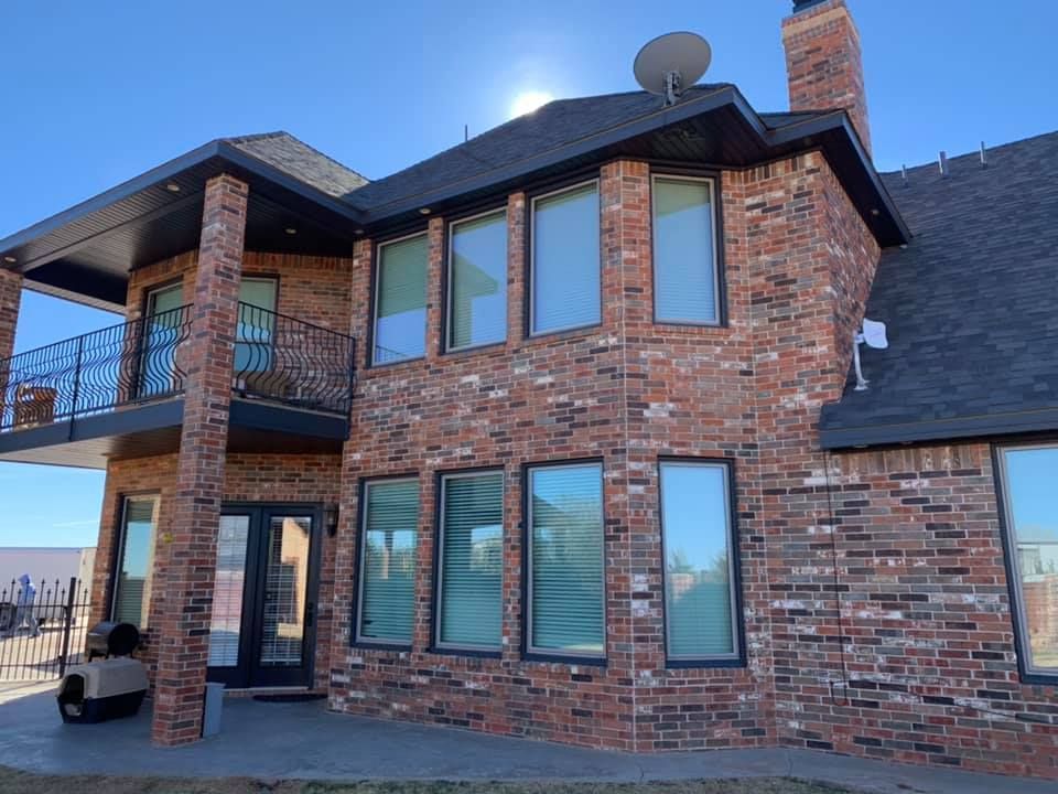 A large brick house with a lot of windows and a balcony.