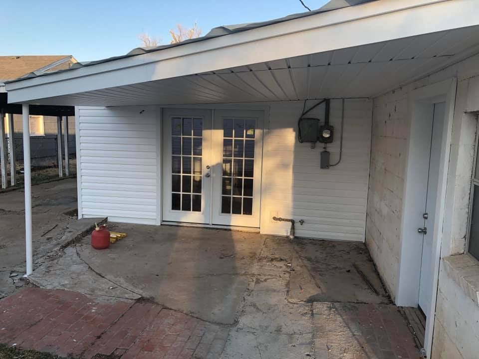 A white house with a covered porch and french doors