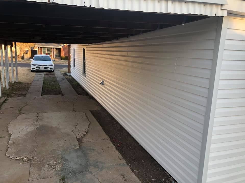 A white car is parked under a white building