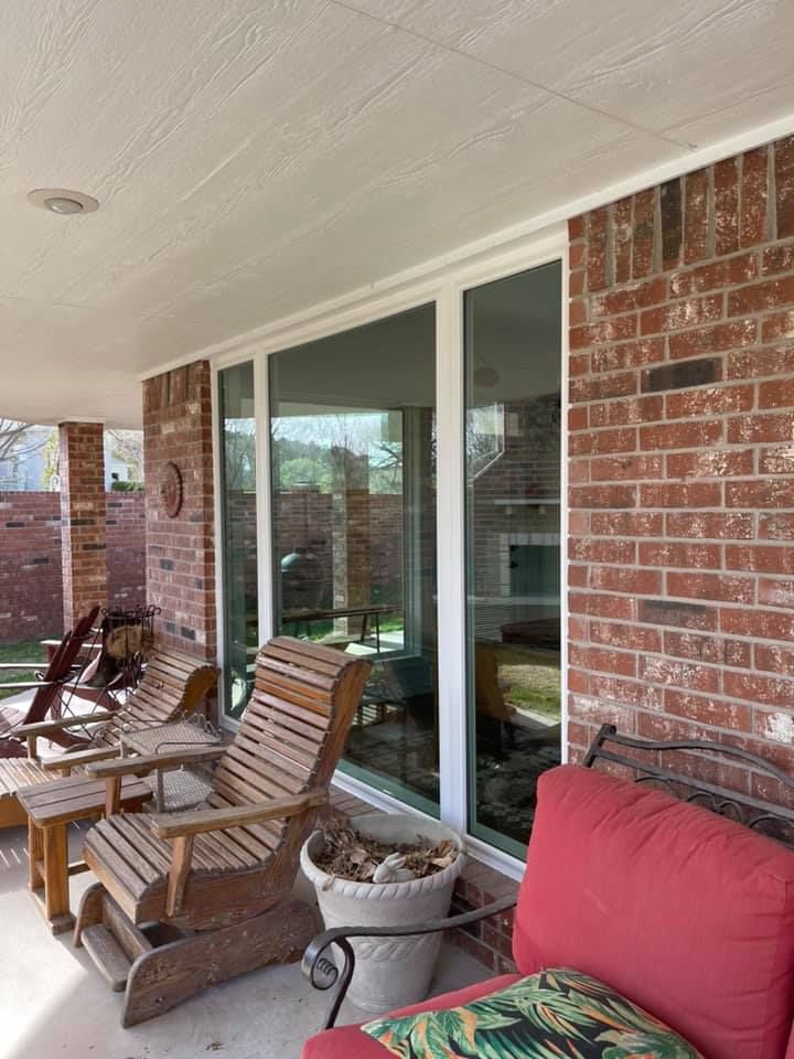 A patio with chairs , a couch , and a potted plant.