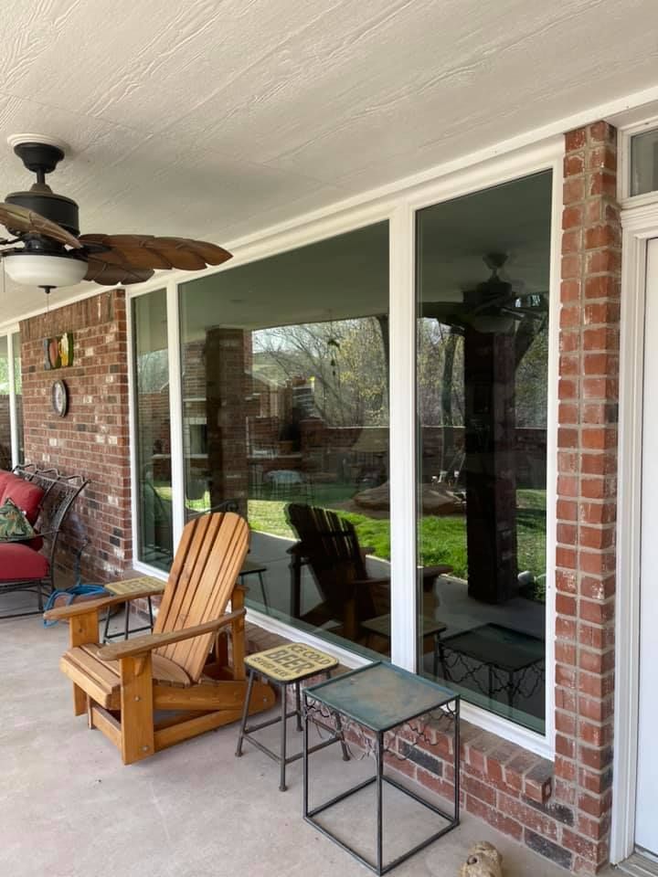 A patio with chairs , tables , and a ceiling fan.