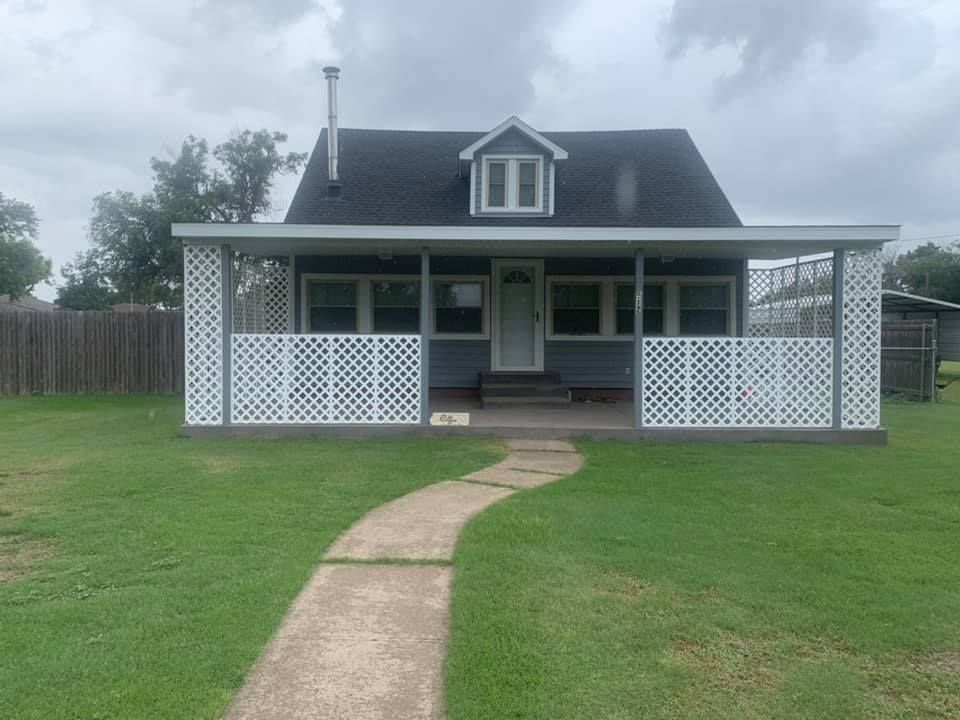 A small house with a porch and a walkway leading to it.