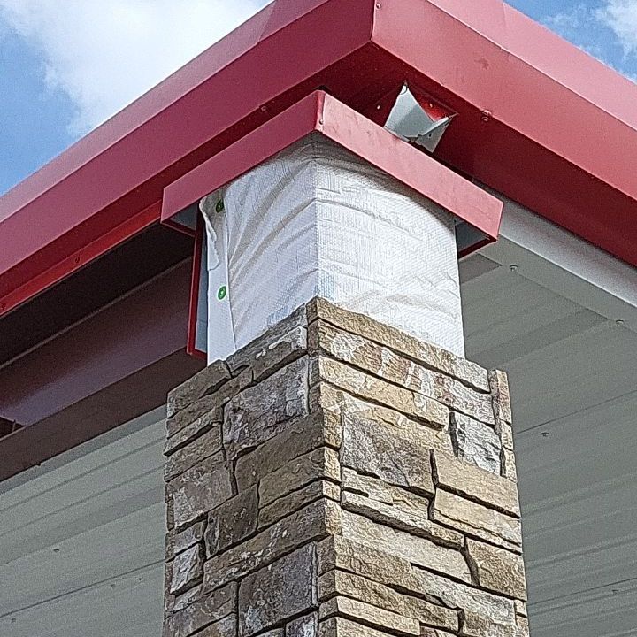 A brick chimney with a red roof on top of it