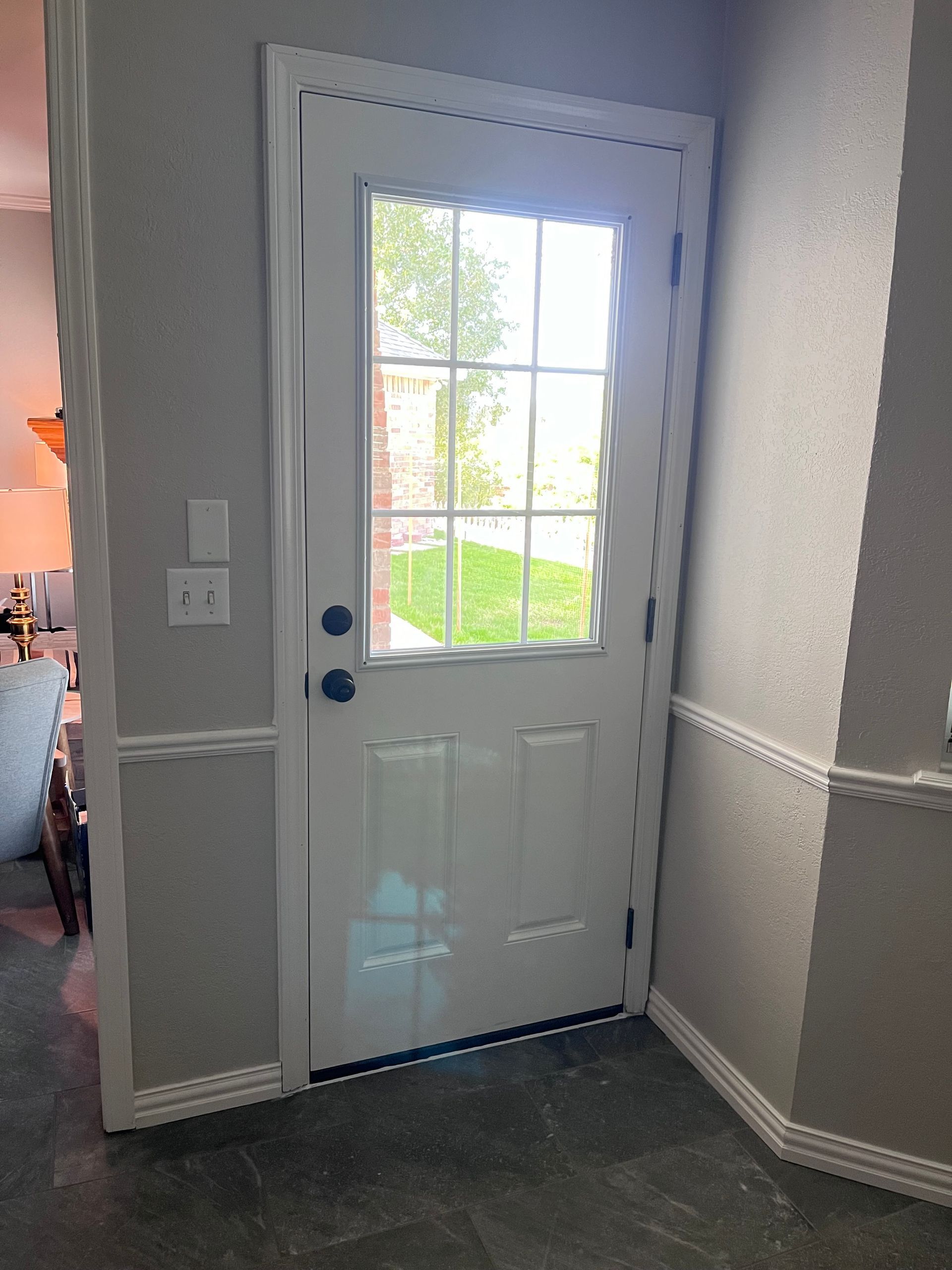 A white door with a window in a hallway.