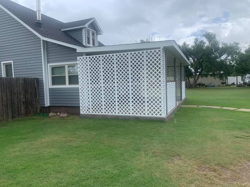 A house with a white lattice fence in front of it.