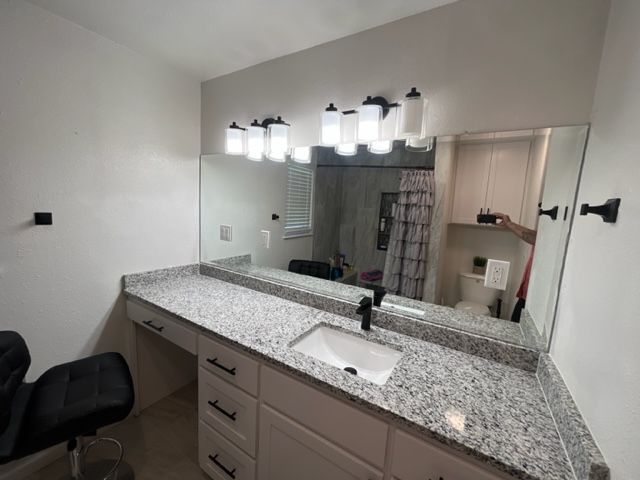 A bathroom with a large mirror and a sink.