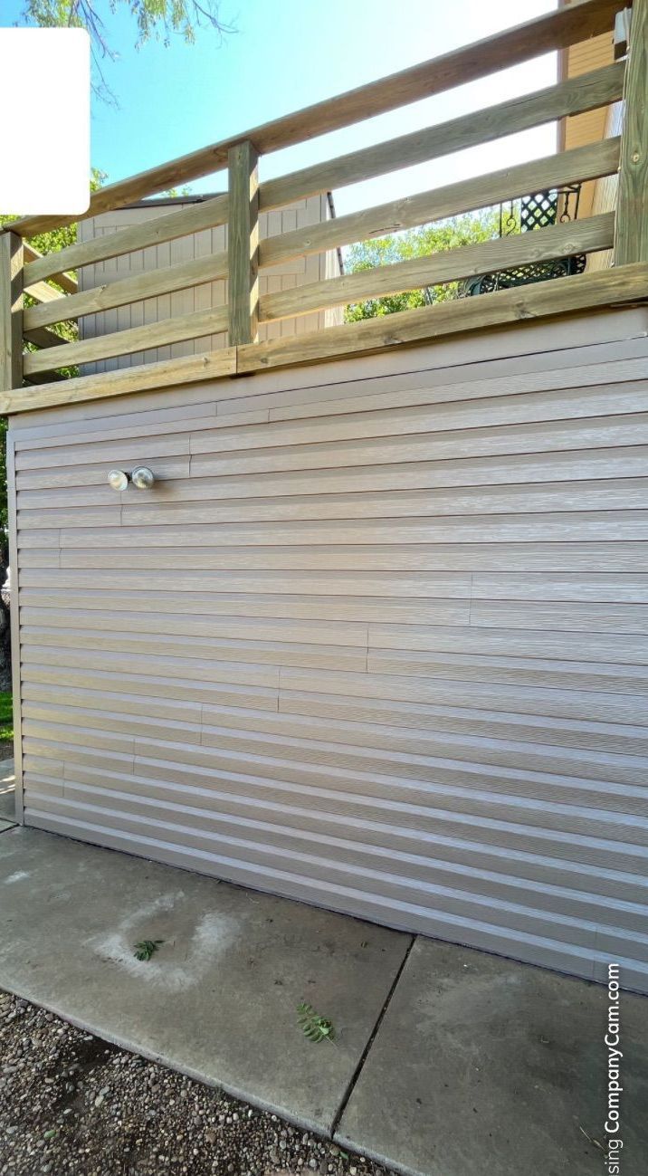 A white garage door with a wooden railing on top of it.