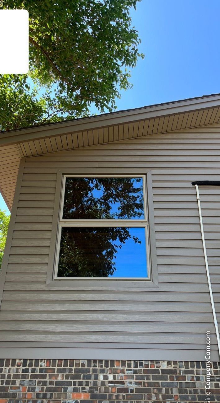 A house with a window and a tree in the background.