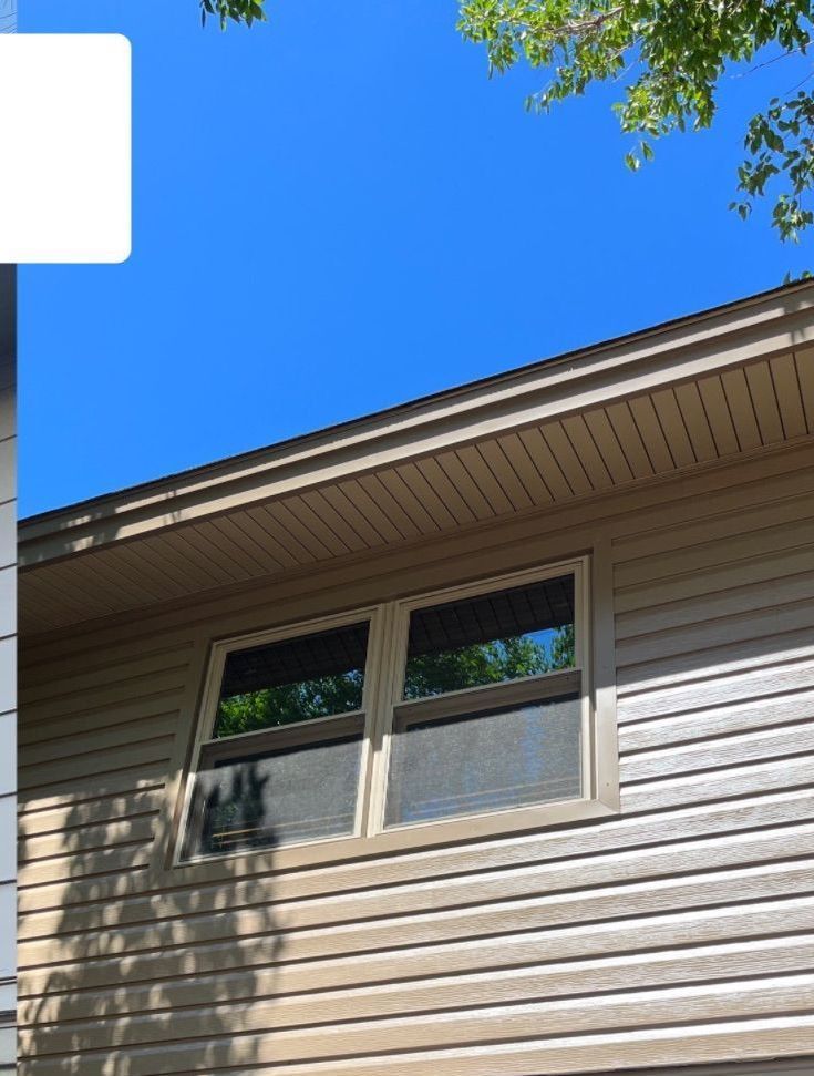 A house with two windows and a blue sky in the background