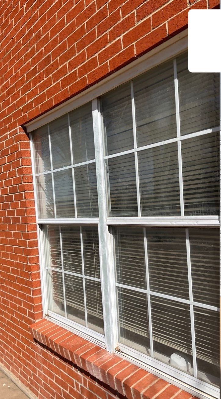 There is a window on the side of a brick building.