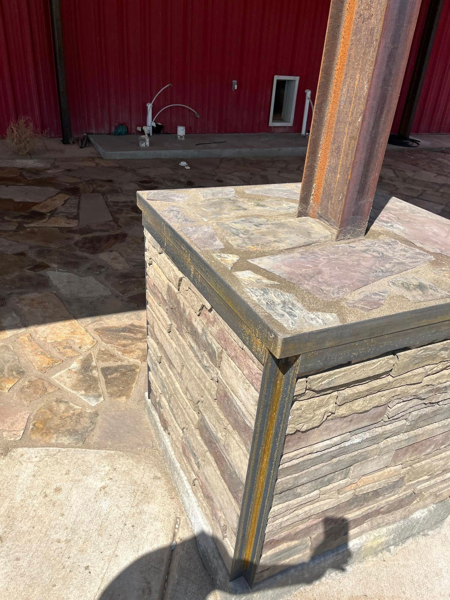 A wooden box is sitting on top of a stone block in front of a red building.