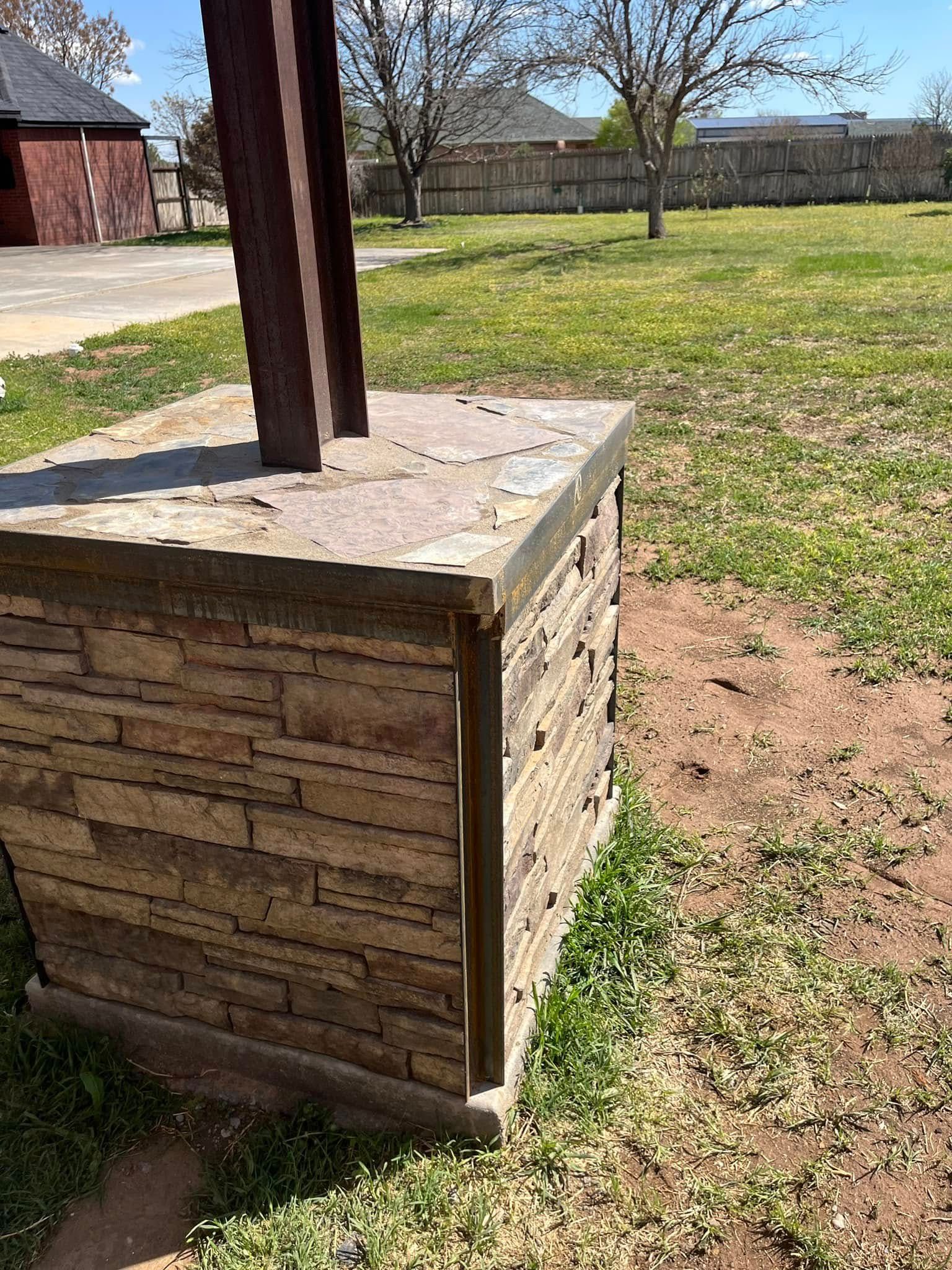 A brick building is sitting in the middle of a grassy field.
