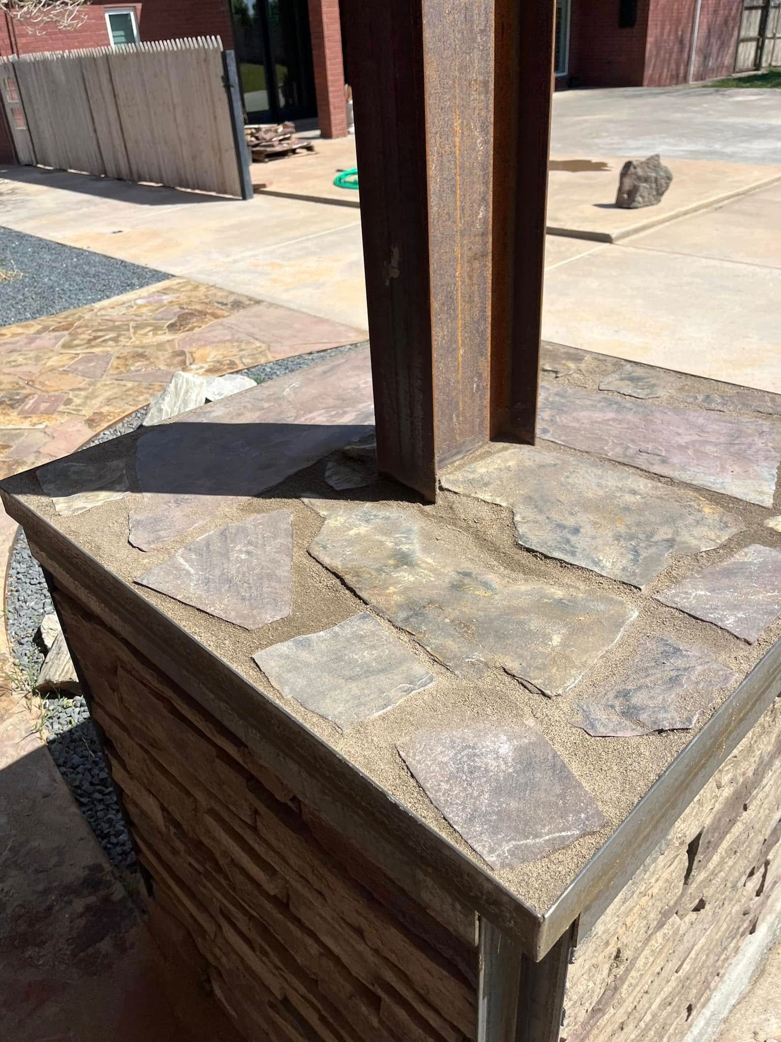 A wooden post is sitting on top of a stone pillar.