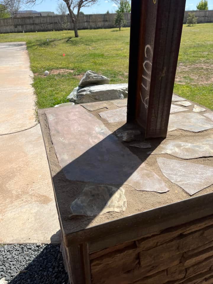 A wooden post is sitting on top of a stone patio.