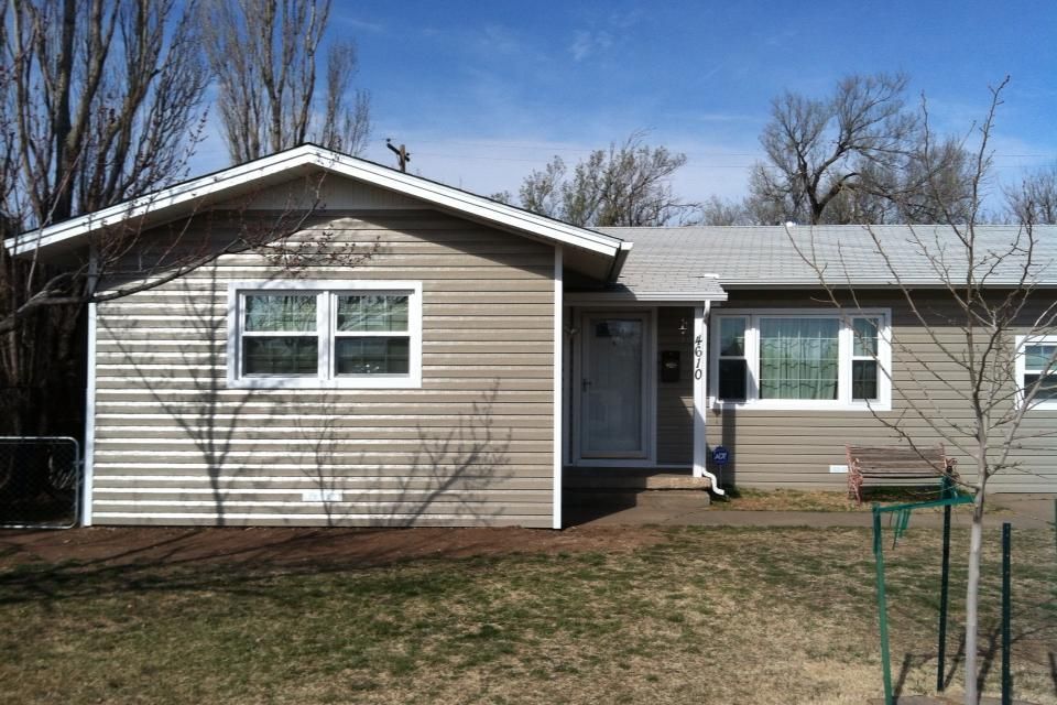 A small house with a white roof and a lot of windows.