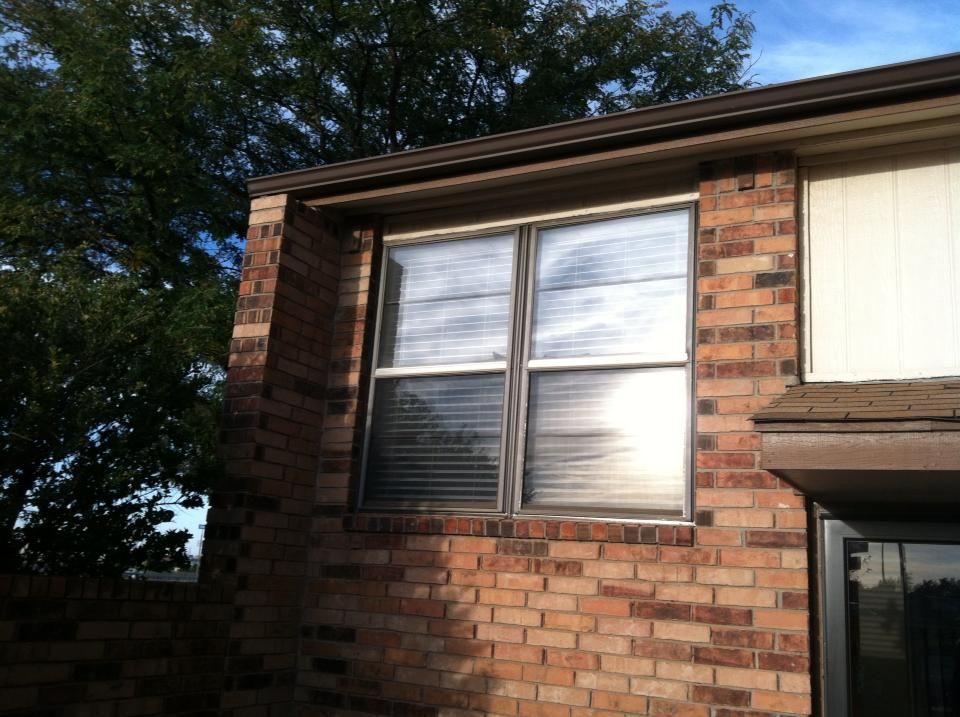 A brick building with a window with blinds on it