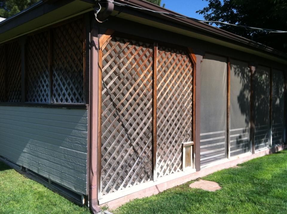 A house with a screened in porch and a dog door