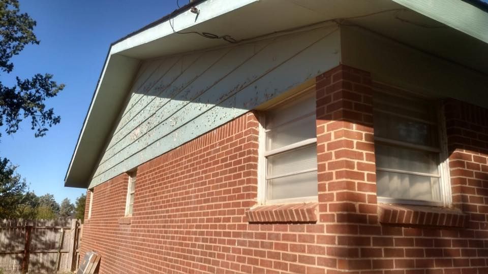 A red brick house with a green roof