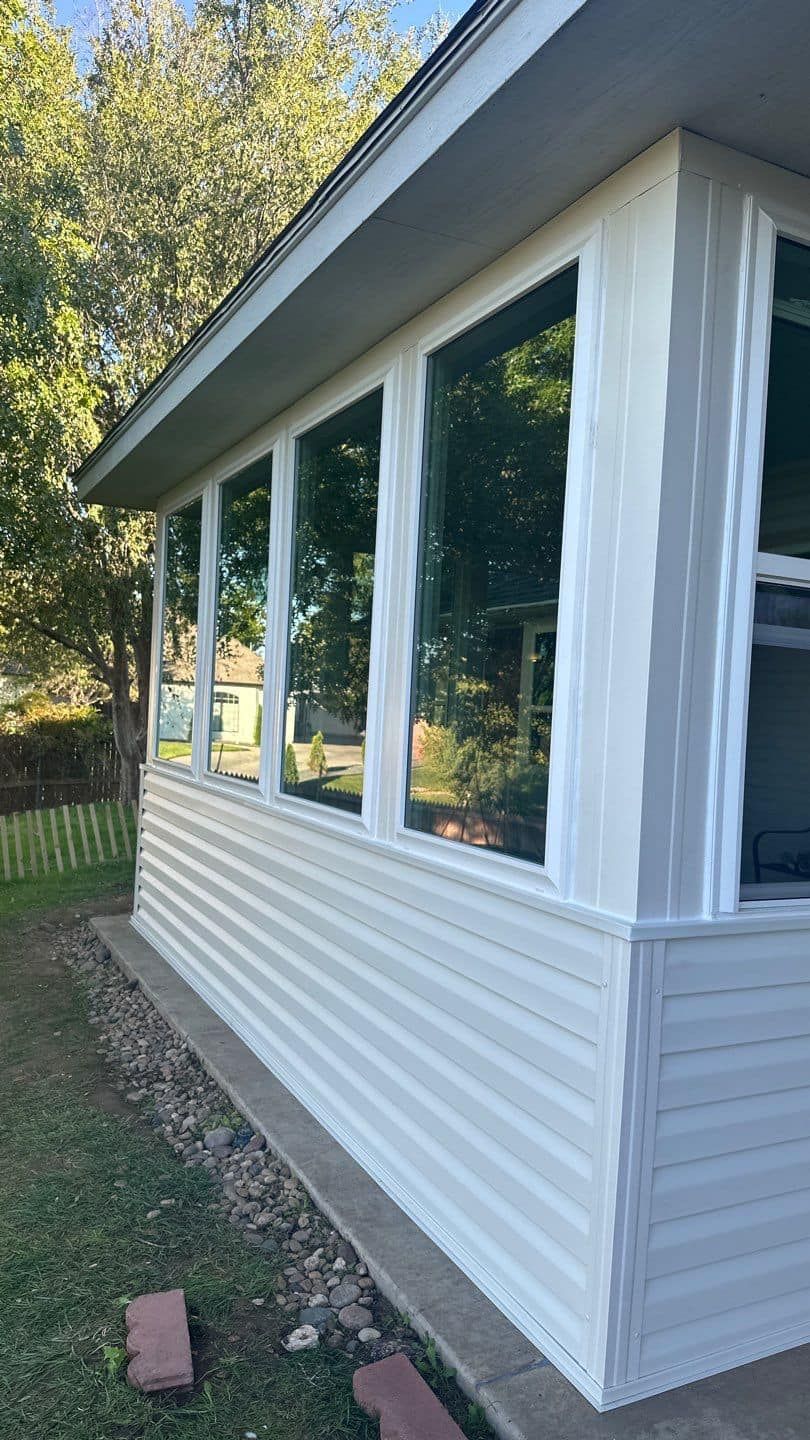 A white house with a lot of windows on the side of it.