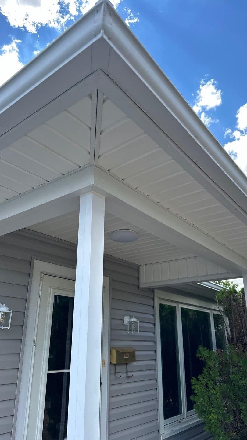 The front of a house with a porch and a white gutter.