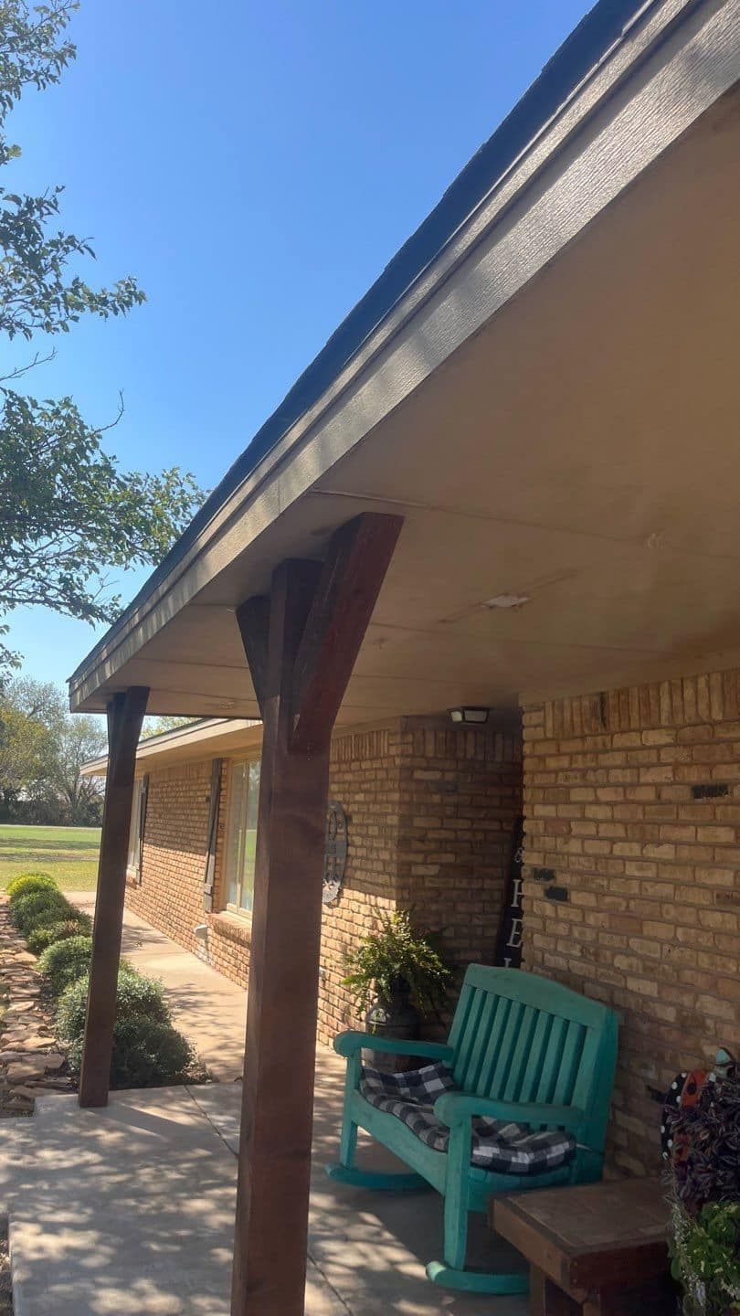 There is a blue rocking chair on the porch of a house.