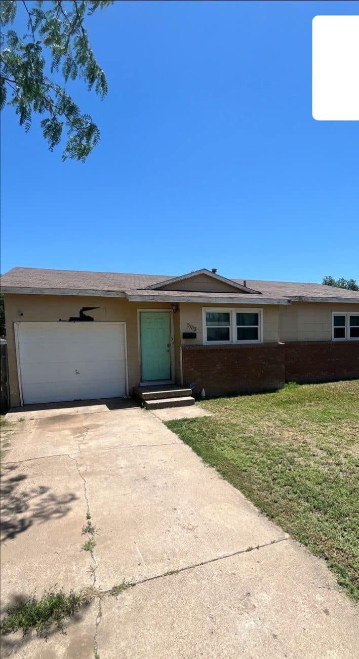 A house with a white garage door and a green door.