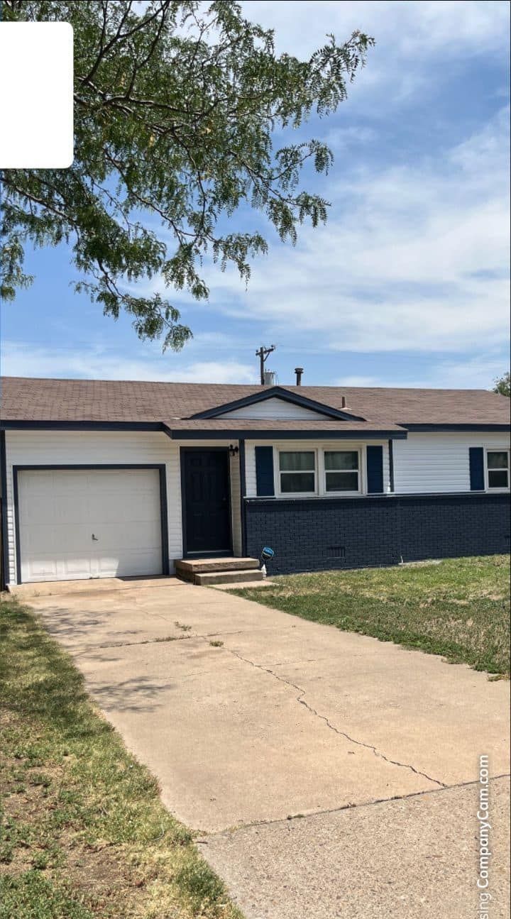 A picture of a house with a garage and a driveway.