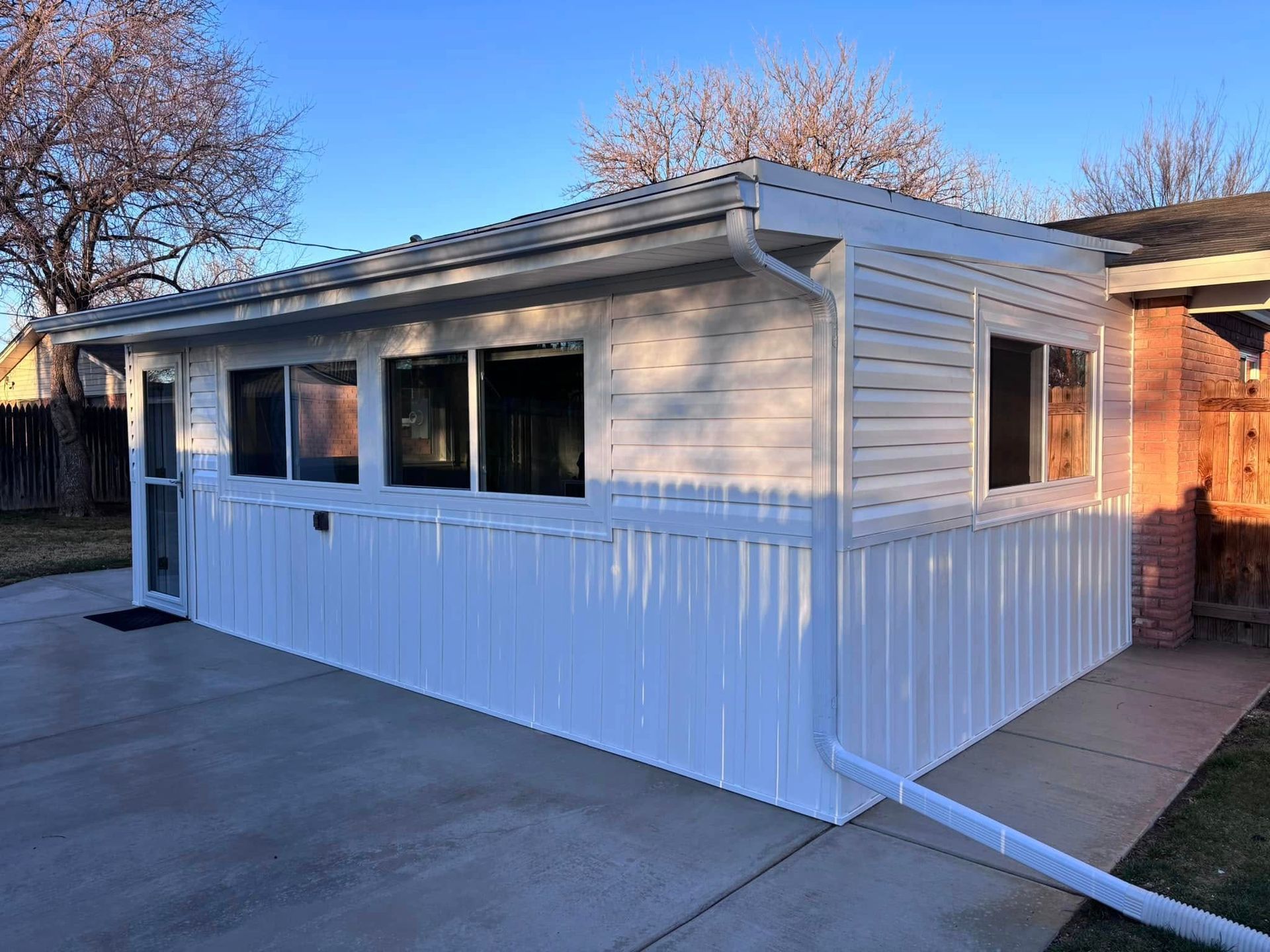A white house with a lot of windows and a driveway.